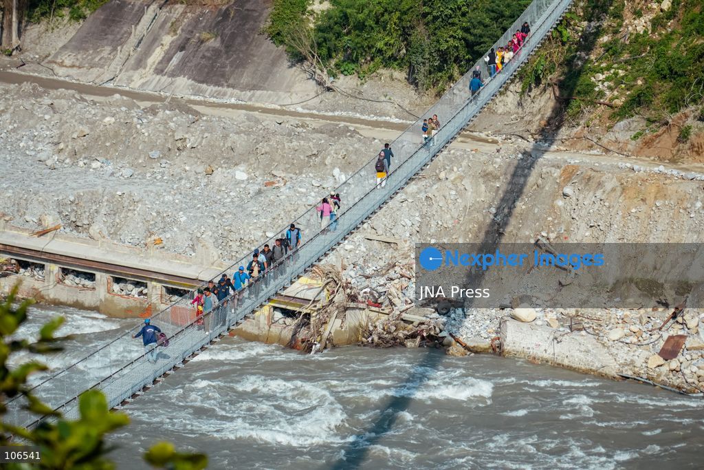 NUWAKOT, NEPAL, OCTOBER 15, 2026: People cross a newly built suspension bridge over the Trishuli River in Bidur Municipality, Nuwakot District. The footbridge restores access between communities after flooding along the Bhotekoshi–Trishuli river corridor swept away road bridges and disrupted local transport. Photo by Ambir Tolang / JNA Press. (Photo by Ambir Tolang/JNA Press via Nexpher Images)