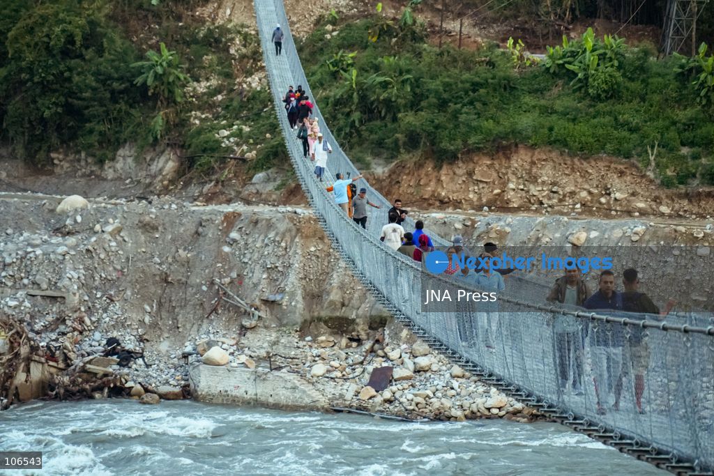 NUWAKOT, NEPAL, OCTOBER 15, 2026: People cross a newly built suspension bridge over the Trishuli River in Bidur Municipality, Nuwakot District. The footbridge restores access between communities after flooding along the Bhotekoshi–Trishuli river corridor swept away road bridges and disrupted local transport. Photo by Ambir Tolang / JNA Press. (Photo by Ambir Tolang/JNA Press via Nexpher Images)