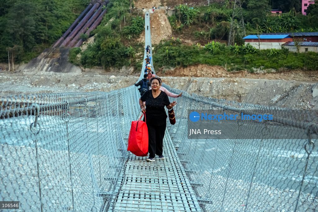 NUWAKOT, NEPAL, OCTOBER 15, 2026: People cross a newly built suspension bridge over the Trishuli River in Bidur Municipality, Nuwakot District. The footbridge restores access between communities after flooding along the Bhotekoshi–Trishuli river corridor swept away road bridges and disrupted local transport. Photo by Ambir Tolang / JNA Press. (Photo by Ambir Tolang/JNA Press via Nexpher Images)