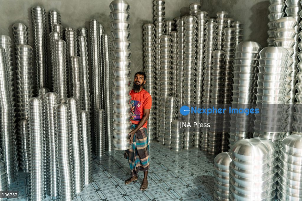 DHAKA, BANGLADESH, OCTOBER 16, 2026: Children work alongside adults at an aluminium cookware factory in Kamrangirchar, Dhaka. Workers handle materials, shape metal and organise finished pots, pans and other household utensils at the small-scale workshop. Photo by Shamim Ul Islam / JNA Press. (Photo by Md shamim Ul islam/JNA Press via Nexpher Images)