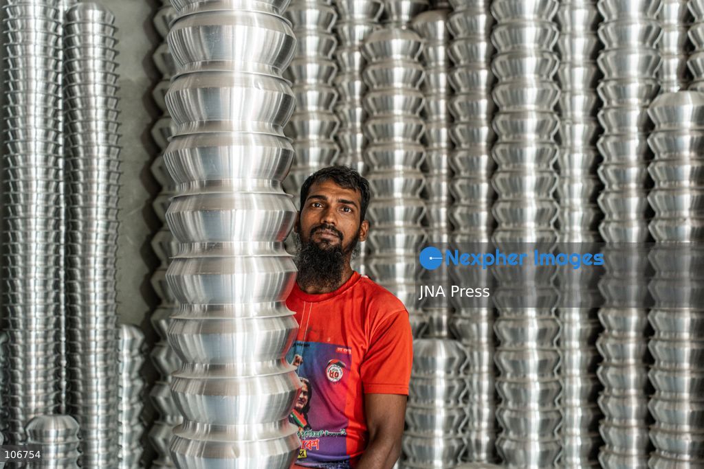 DHAKA, BANGLADESH, OCTOBER 16, 2026: Children work alongside adults at an aluminium cookware factory in Kamrangirchar, Dhaka. Workers handle materials, shape metal and organise finished pots, pans and other household utensils at the small-scale workshop. Photo by Shamim Ul Islam / JNA Press. (Photo by Md shamim Ul islam/JNA Press via Nexpher Images)
