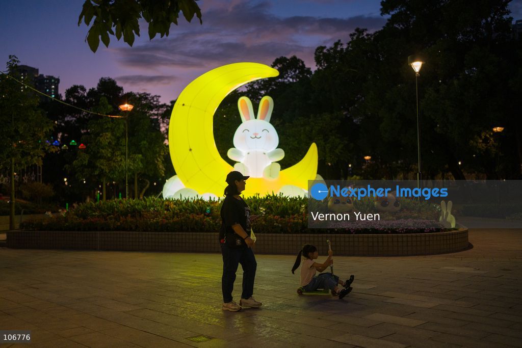 A woman and a girl walking pass a moon themed light display on October 17, 2026 in Hong Kong. (Photo by Vernon Yuen/Nexpher Images)