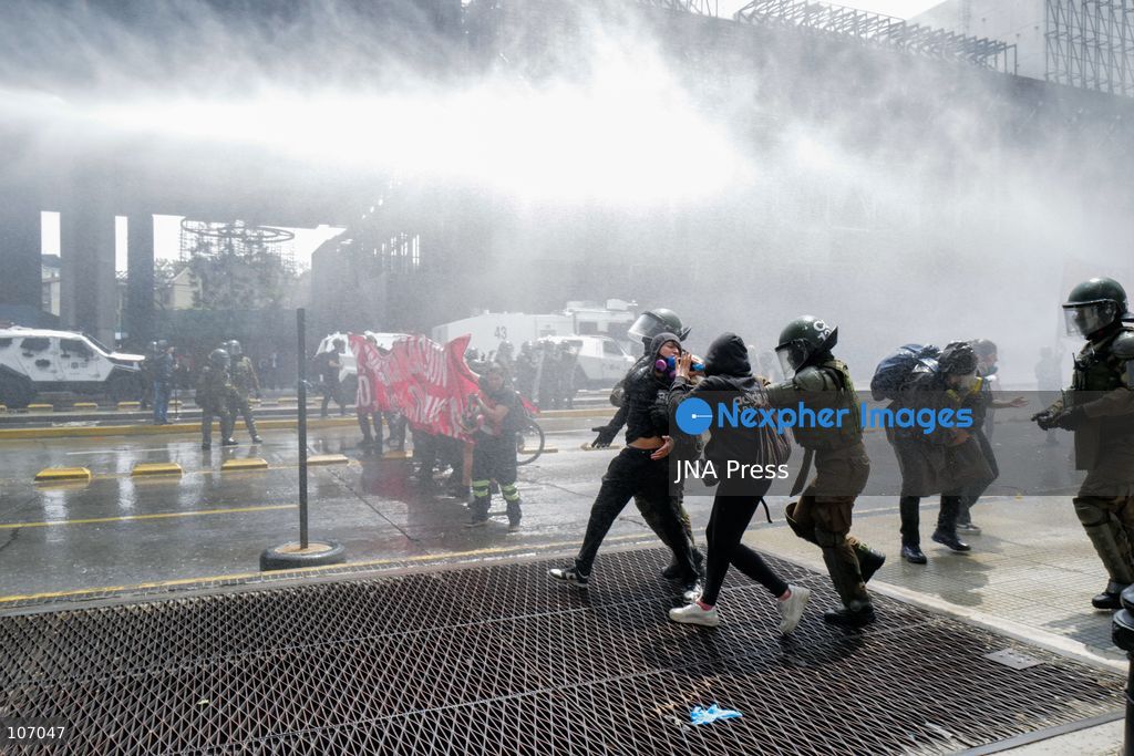 SANTIAGO, CHILE - OCTOBER 18, 2026: Carabineros officers detain a demonstrator amid a white cloud outside the GAM during the seventh anniversary of Chile's 2019 social uprising. (Photo by Pablo Zamorano/JNA Press via Nexpher Images)