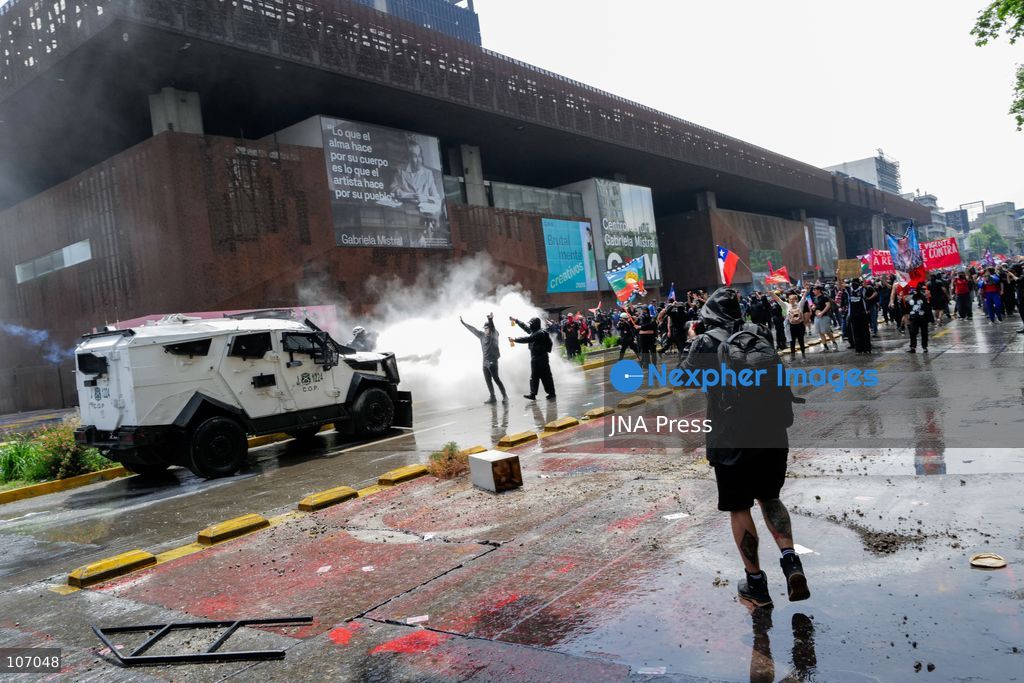 SANTIAGO, CHILE - OCTOBER 18, 2026: Demonstrators gather near an armored Carabineros vehicle amid a white cloud outside the Gabriela Mistral Cultural Center (GAM) during the seventh anniversary of Chile's 2019 social uprising. (Photo by Pablo Zamorano/JNA Press via Nexpher Images)