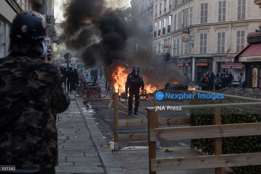 PARIS, FRANCE - OCTOBER 18, 2026: Protesters clash with police near Place de la République in Paris during a protest against austerity. Protesters set up makeshift barricades and start fires in the square and surrounding streets. After police clear the square, protesters attack nearby shops. (Photo by Oualid Abdellaoui/JNA Press via Nexpher Images)