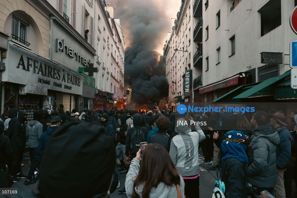 PARIS, FRANCE - OCTOBER 18, 2026: Protesters clash with police near Place de la République in Paris during a protest against austerity. Protesters set up makeshift barricades and start fires in the square and surrounding streets. After police clear the square, protesters attack nearby shops. (Photo by Oualid Abdellaoui/JNA Press via Nexpher Images)