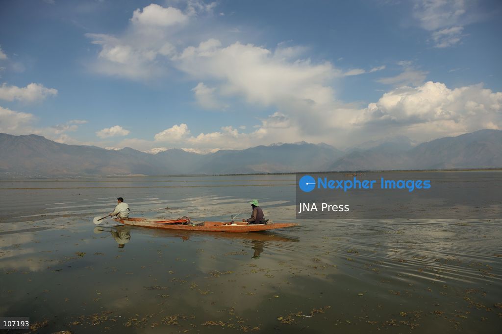 BANDIPORA, INDIA - OCTOBER 19, 2026: Fishermen cast their nets while women and other workers collect water chestnuts at Wular Lake in Bandipora district of Kashmir. Many families in the area earn their livelihoods from the lake's waters. (Photo by Kamran Yousuf/JNA Press via Nexpher Images)