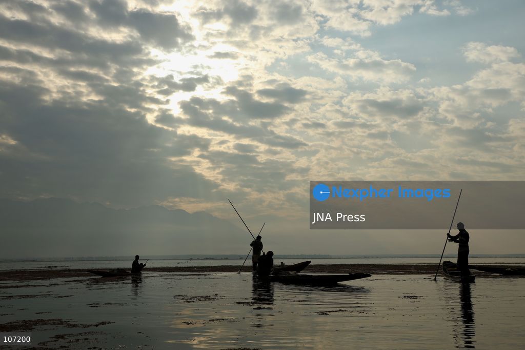 BANDIPORA, INDIA - OCTOBER 19, 2026: Fishermen cast their nets while women and other workers collect water chestnuts at Wular Lake in Bandipora district of Kashmir. Many families in the area earn their livelihoods from the lake's waters. (Photo by Kamran Yousuf/JNA Press via Nexpher Images)