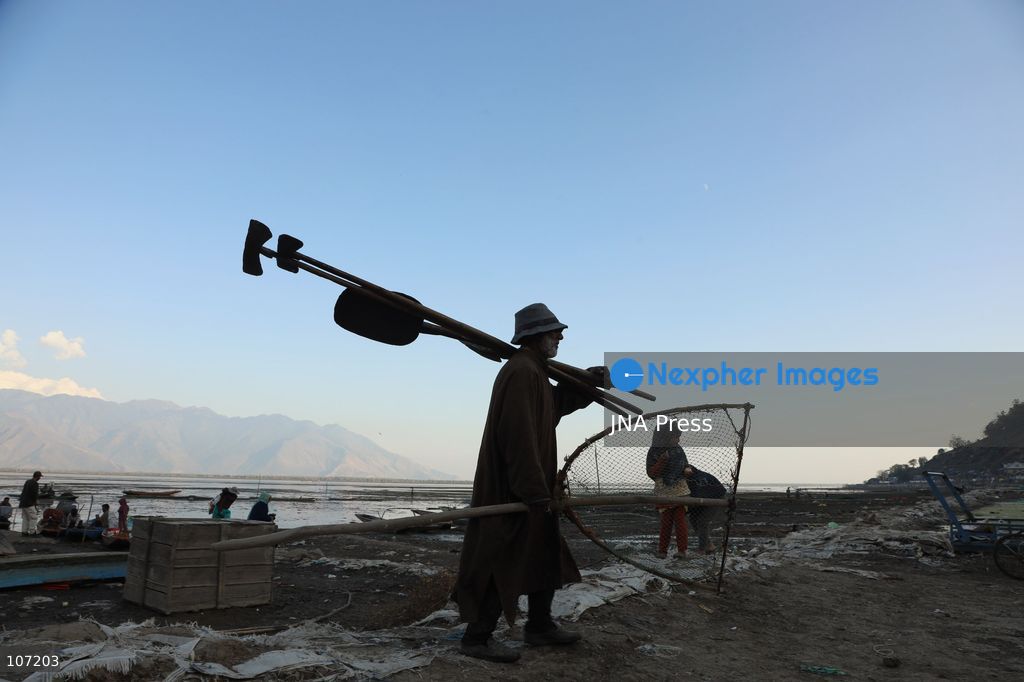 BANDIPORA, INDIA - OCTOBER 19, 2026: Fishermen cast their nets while women and other workers collect water chestnuts at Wular Lake in Bandipora district of Kashmir. Many families in the area earn their livelihoods from the lake's waters. (Photo by Kamran Yousuf/JNA Press via Nexpher Images)