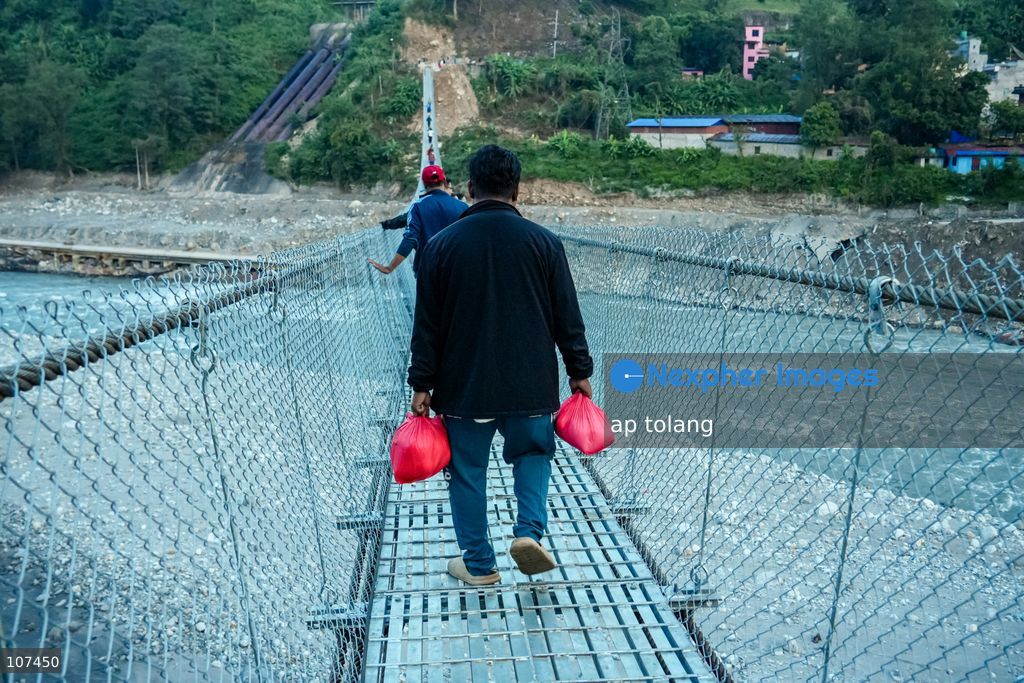 Rasuwa, NEPAL, October 15, 2026: People cross the Trishuli River on a newly installed suspension bridge connecting Trisuli Bazaar in Nuwakot district, Nepal. The bridge provides a crossing over the river for local residents. (Photo by ap tolang/Nexpher Images)