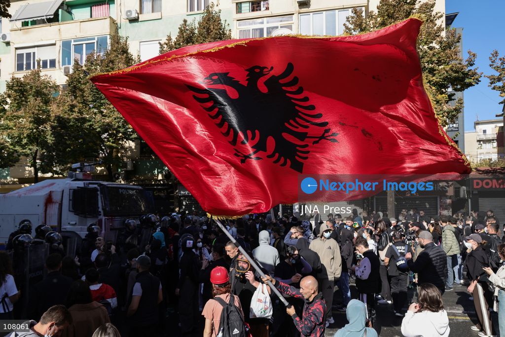 TIRANA, ALBANIA - OCTOBER 20, 2026: Anti-government protests continue in Tirana for an eighth consecutive day, with demonstrators gathering in central areas of the capital, including Skanderbeg Square. Protesters call for the resignation of Prime Minister Edi Rama, demanding improvements to university conditions and broader political change. Tensions escalate as Albanian riot police fire tear gas to disperse demonstrators. One protester collapses in Skanderbeg Square after tear gas is deployed. Amid the confrontations, a young demonstrator is also seen reaching out to shake hands with a riot police officer, offering a contrasting moment during the tense demonstrations. The protests reflect growing public discontent and continued tensions between demonstrators and the authorities. (Photo by Vlasov Sulaj/JNA Press via Nexpher Images)