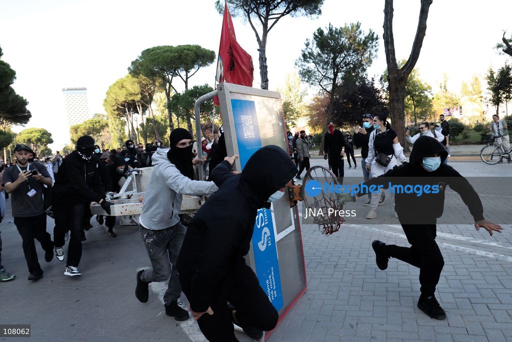 TIRANA, ALBANIA - OCTOBER 20, 2026: Anti-government protests continue in Tirana for an eighth consecutive day, with demonstrators gathering in central areas of the capital, including Skanderbeg Square. Protesters call for the resignation of Prime Minister Edi Rama, demanding improvements to university conditions and broader political change. Tensions escalate as Albanian riot police fire tear gas to disperse demonstrators. One protester collapses in Skanderbeg Square after tear gas is deployed. Amid the confrontations, a young demonstrator is also seen reaching out to shake hands with a riot police officer, offering a contrasting moment during the tense demonstrations. The protests reflect growing public discontent and continued tensions between demonstrators and the authorities. (Photo by Vlasov Sulaj/JNA Press via Nexpher Images)