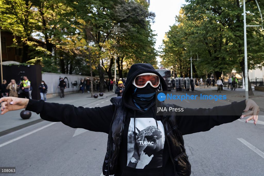 TIRANA, ALBANIA - OCTOBER 20, 2026: Anti-government protests continue in Tirana for an eighth consecutive day, with demonstrators gathering in central areas of the capital, including Skanderbeg Square. Protesters call for the resignation of Prime Minister Edi Rama, demanding improvements to university conditions and broader political change. Tensions escalate as Albanian riot police fire tear gas to disperse demonstrators. One protester collapses in Skanderbeg Square after tear gas is deployed. Amid the confrontations, a young demonstrator is also seen reaching out to shake hands with a riot police officer, offering a contrasting moment during the tense demonstrations. The protests reflect growing public discontent and continued tensions between demonstrators and the authorities. (Photo by Vlasov Sulaj/JNA Press via Nexpher Images)