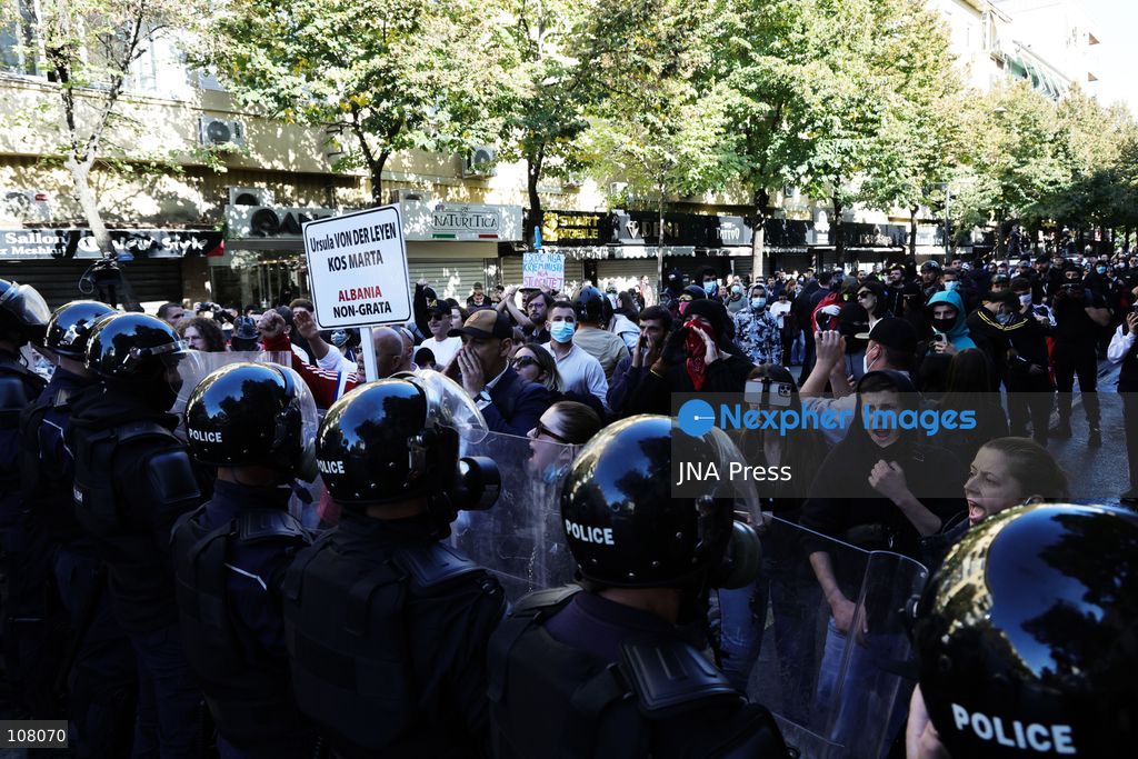 TIRANA, ALBANIA - OCTOBER 20, 2026: Anti-government protests continue in Tirana for an eighth consecutive day, with demonstrators gathering in central areas of the capital, including Skanderbeg Square. Protesters call for the resignation of Prime Minister Edi Rama, demanding improvements to university conditions and broader political change. Tensions escalate as Albanian riot police fire tear gas to disperse demonstrators. One protester collapses in Skanderbeg Square after tear gas is deployed. Amid the confrontations, a young demonstrator is also seen reaching out to shake hands with a riot police officer, offering a contrasting moment during the tense demonstrations. The protests reflect growing public discontent and continued tensions between demonstrators and the authorities. (Photo by Vlasov Sulaj/JNA Press via Nexpher Images)