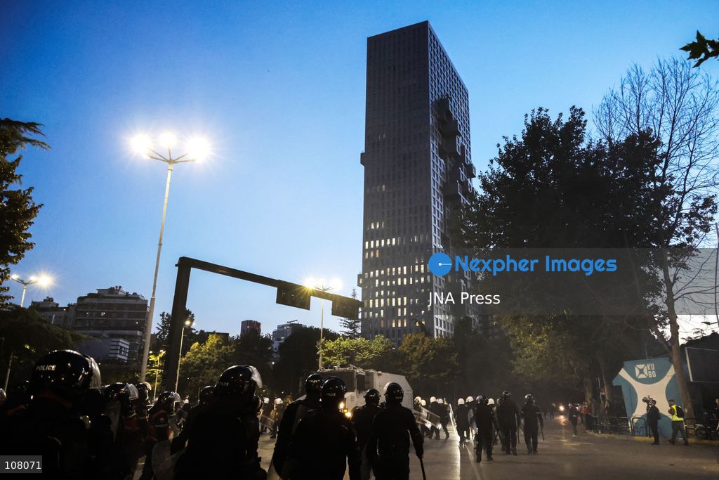 TIRANA, ALBANIA - OCTOBER 20, 2026: Anti-government protests continue in Tirana for an eighth consecutive day, with demonstrators gathering in central areas of the capital, including Skanderbeg Square. Protesters call for the resignation of Prime Minister Edi Rama, demanding improvements to university conditions and broader political change. Tensions escalate as Albanian riot police fire tear gas to disperse demonstrators. One protester collapses in Skanderbeg Square after tear gas is deployed. Amid the confrontations, a young demonstrator is also seen reaching out to shake hands with a riot police officer, offering a contrasting moment during the tense demonstrations. The protests reflect growing public discontent and continued tensions between demonstrators and the authorities. (Photo by Vlasov Sulaj/JNA Press via Nexpher Images)
