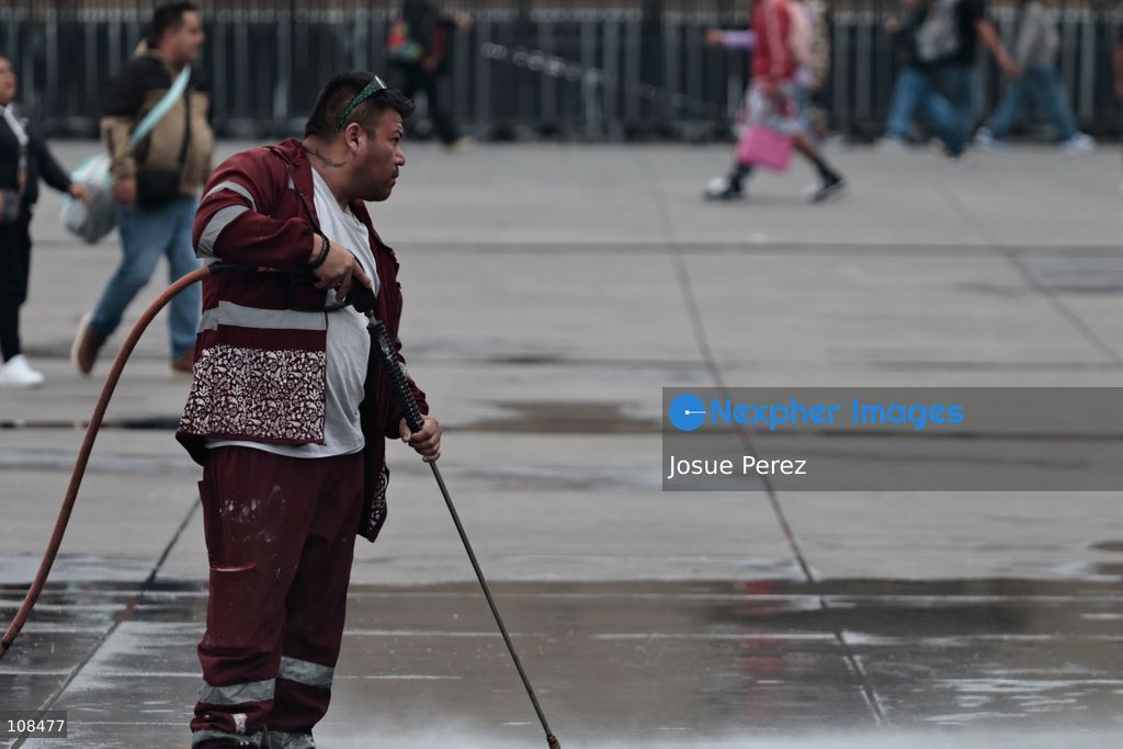 Cleaning workers wash and remove stains from the floor of the Plaza de la Constitución to prepare it for the installation of the monumental *ofrenda* (altar) and the world’s tallest *Catrina* figure, in celebration of the Day of the Dead, on October 22, 2026, in Mexico City, Mexico. Construction crews working for the Mexico City government have begun assembling and installing the structures that will illuminate the buildings surrounding the city’s Zócalo. Using cranes, cables, and various framework components, they are preparing everything for the unveiling of the Monumental Ofrenda (altar), which will feature the world’s tallest Catrina, so that both locals and tourists can enjoy the start of the Day of the Dead celebrations in Mexico. (Photo by Josue Perez/Nexpher Images)