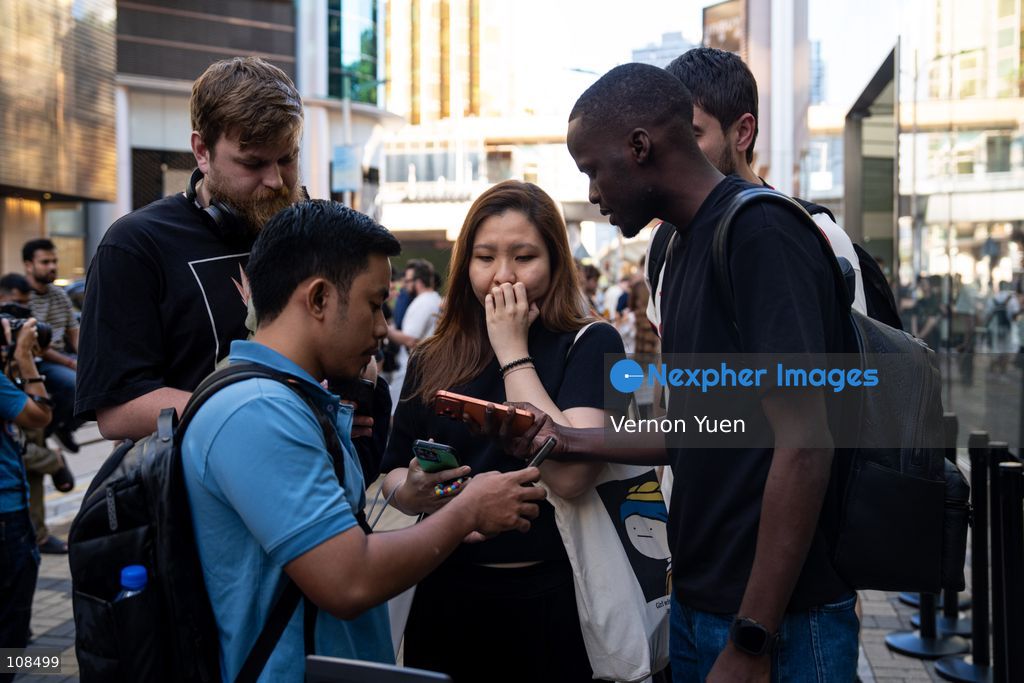 iPhone resellers trying to buy an iPhone Duo from a woman outside an Apple Store on October 22, 2026 in Hong Kong. The iPhone DUO is Apple INC.’s first foldable phone, today is the first day the new iPhone DUO is available to the public. (Photo by Vernon Yuen/Nexpher Images)