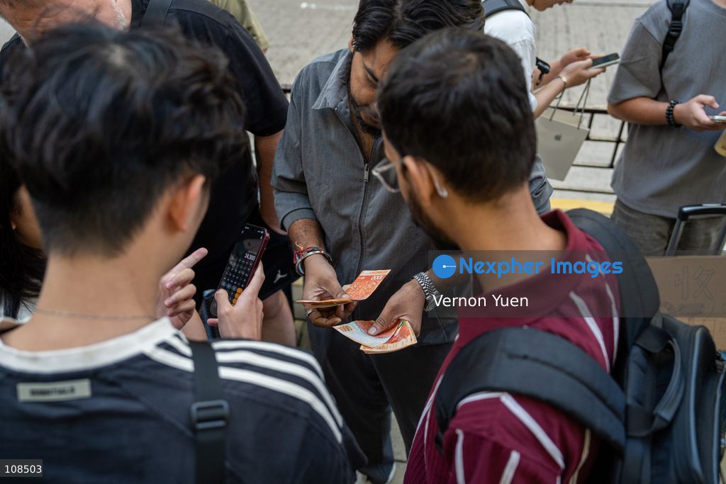 Iphone resellers counting money outside an Apple Store on October 22, 2026 in Hong Kong. The iPhone DUO is Apple INC.’s first foldable phone, today is the first day the new iPhone DUO is available to the public. (Photo by Vernon Yuen/Nexpher Images)