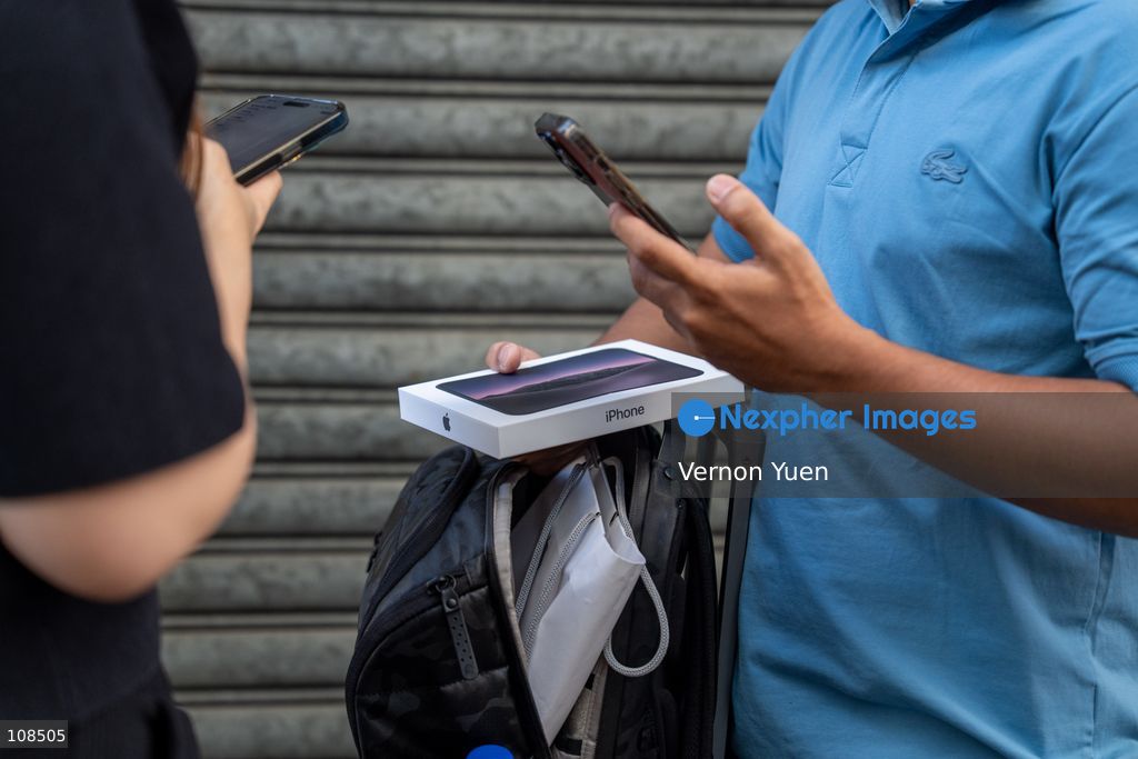 iPhone resellers trying to buy an iPhone Duo from a customers outside an Apple Store on October 22, 2026 in Hong Kong. The iPhone DUO is Apple INC.’s first foldable phone, today is the first day the new iPhone DUO is available to the public. (Photo by Vernon Yuen/Nexpher Images)