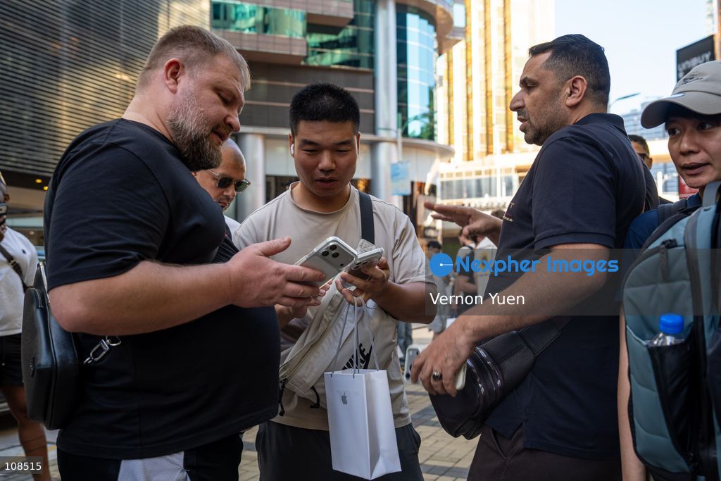 iPhone resellers buying an iPhone Duo from a customer outside an Apple Store on October 22, 2026 in Hong Kong. The iPhone DUO is Apple INC.’s first foldable phone, today is the first day the new iPhone DUO is available to the public. (Photo by Vernon Yuen/Nexpher Images)