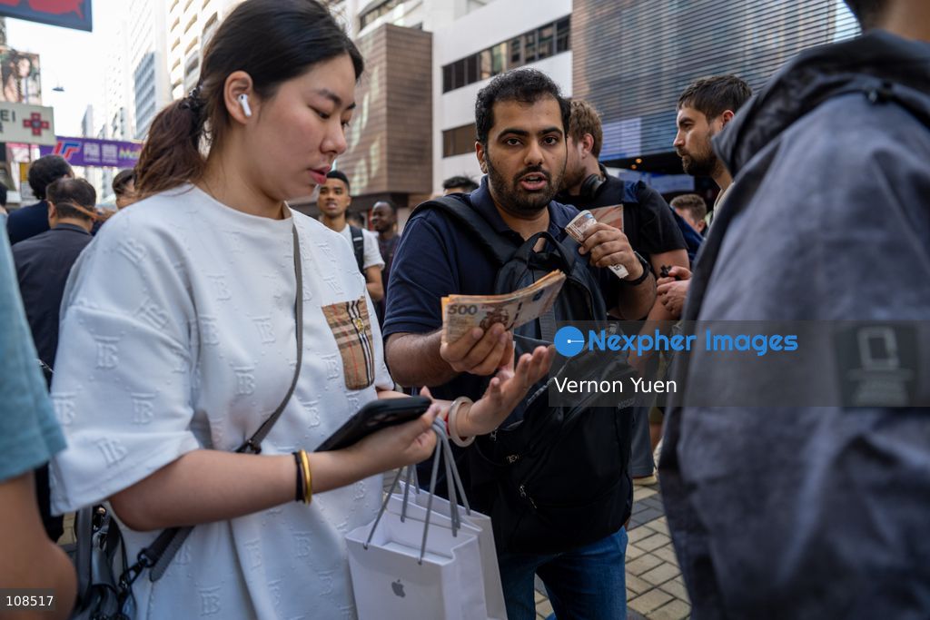 An iPhone reseller trying to buy an iPhone duo from a woman outside an Apple Store on October 22, 2026 in Hong Kong. The iPhone DUO is Apple INC.’s first foldable phone, today is the first day the new iPhone DUO is available to the public. (Photo by Vernon Yuen/Nexpher Images)