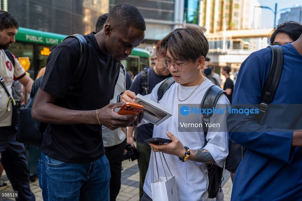 An iPhone reseller trying to buy an iPhone duo from a woman outside an Apple Store on October 22, 2026 in Hong Kong. The iPhone DUO is Apple INC.’s first foldable phone, today is the first day the new iPhone DUO is available to the public. (Photo by Vernon Yuen/Nexpher Images)