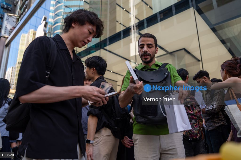 An iPhone reseller trying to buy an iPhone duo from a woman outside an Apple Store on October 22, 2026 in Hong Kong. The iPhone DUO is Apple INC.’s first foldable phone, today is the first day the new iPhone DUO is available to the public. (Photo by Vernon Yuen/Nexpher Images)