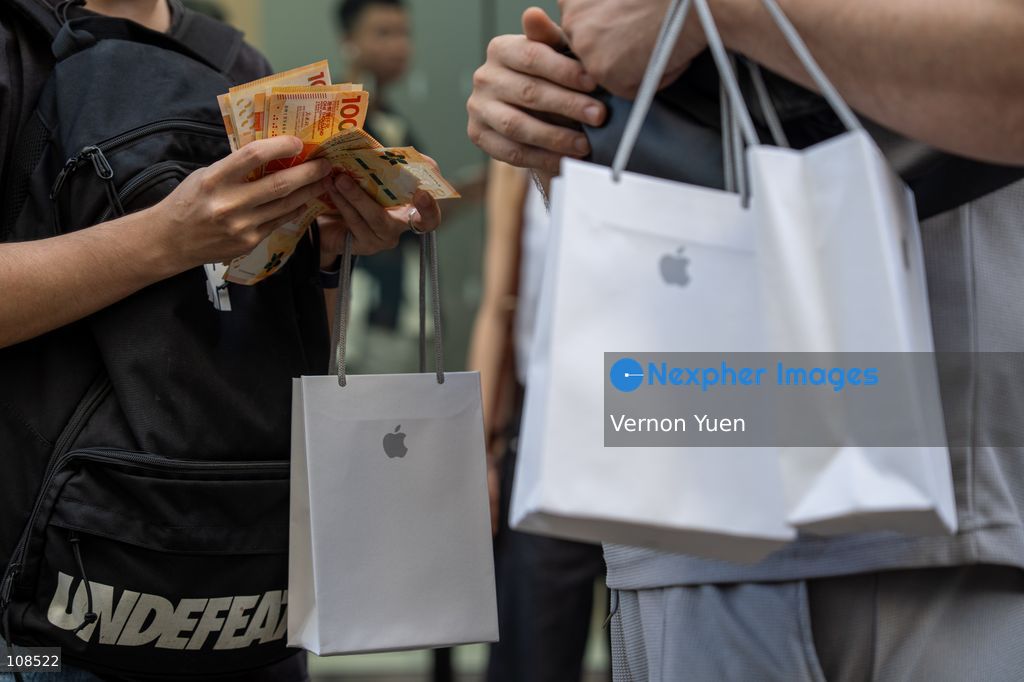 An iPhone reseller trying to buy an iPhone duo from a woman outside an Apple Store on October 22, 2026 in Hong Kong. The iPhone DUO is Apple INC.’s first foldable phone, today is the first day the new iPhone DUO is available to the public. (Photo by Vernon Yuen/Nexpher Images)