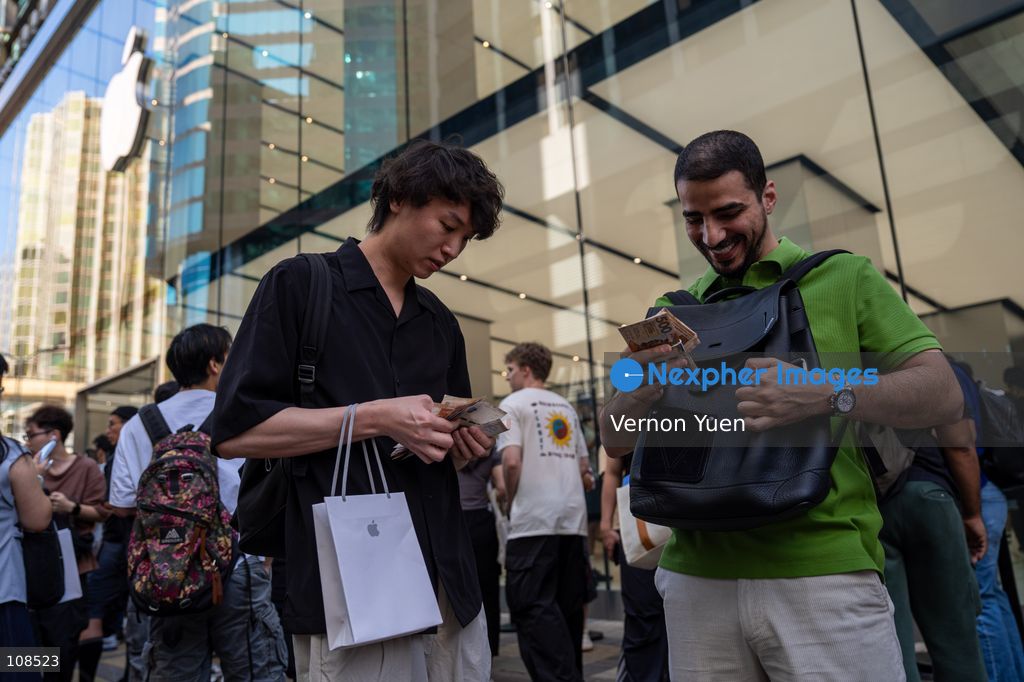 An iPhone reseller trying to buy an iPhone duo from a woman outside an Apple Store on October 22, 2026 in Hong Kong. The iPhone DUO is Apple INC.’s first foldable phone, today is the first day the new iPhone DUO is available to the public. (Photo by Vernon Yuen/Nexpher Images)