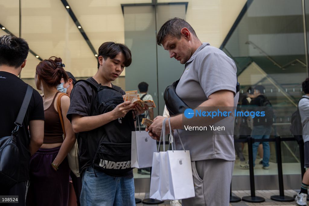 An iPhone reseller trying to buy an iPhone duo from a woman outside an Apple Store on October 22, 2026 in Hong Kong. The iPhone DUO is Apple INC.’s first foldable phone, today is the first day the new iPhone DUO is available to the public. (Photo by Vernon Yuen/Nexpher Images)