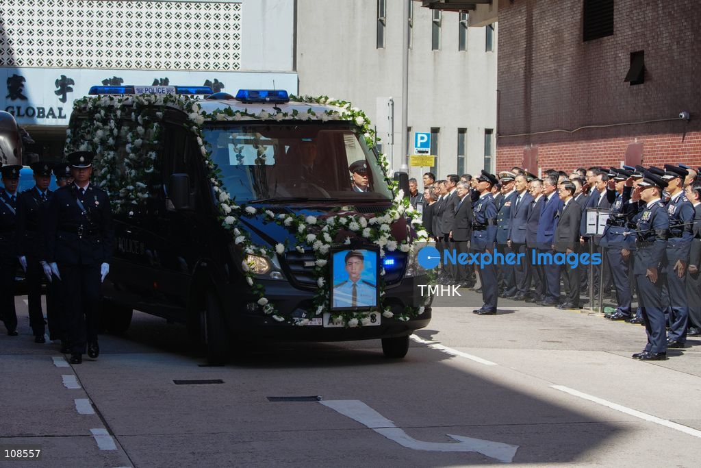 Officials and police officers stand in line as the hearse leaves the Universal Funeral Parlour following the funeral of late police officer Chu Chun-kwok in Hung Hom, Hong Kong, on October 23, 2026. (Photo by Zulu Lo/TMHK via Nexpher Images)