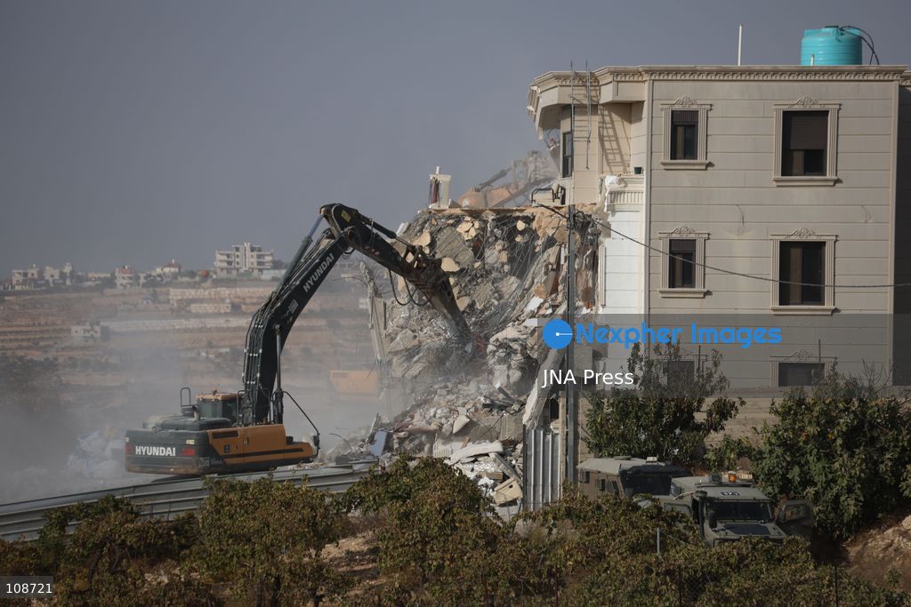 HEBRON, PALESTINE, OCTOBER 23, 2026: Israeli forces demolish a Palestinian residential building in the Farsh al-Hawa area of Hebron in the occupied West Bank. The demolition follows a shooting attack at a nearby military checkpoint earlier in the day and Israeli orders targeting buildings around the attack site. (Photo by Mosab shawer/JNA Press via Nexpher Images)