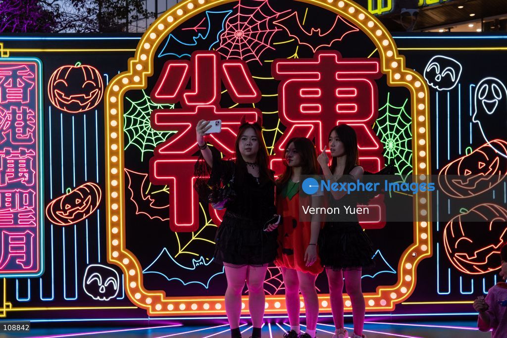 People in costumes posing for a photo with halloween themed displays on October 24, 2026 in Hong Kong. (Photo by Vernon Yuen/Nexpher Images)