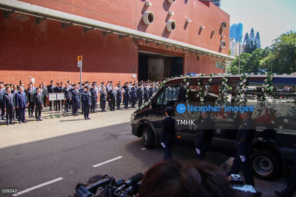 Officials and police officers stand in line as the hearse leaves the Universal Funeral Parlour following the funeral of late police officer Chu Chun-kwok in Hung Hom, Hong Kong, on October 23, 2026. (Photo by Gordon Choi/TMHK via Nexpher Images)