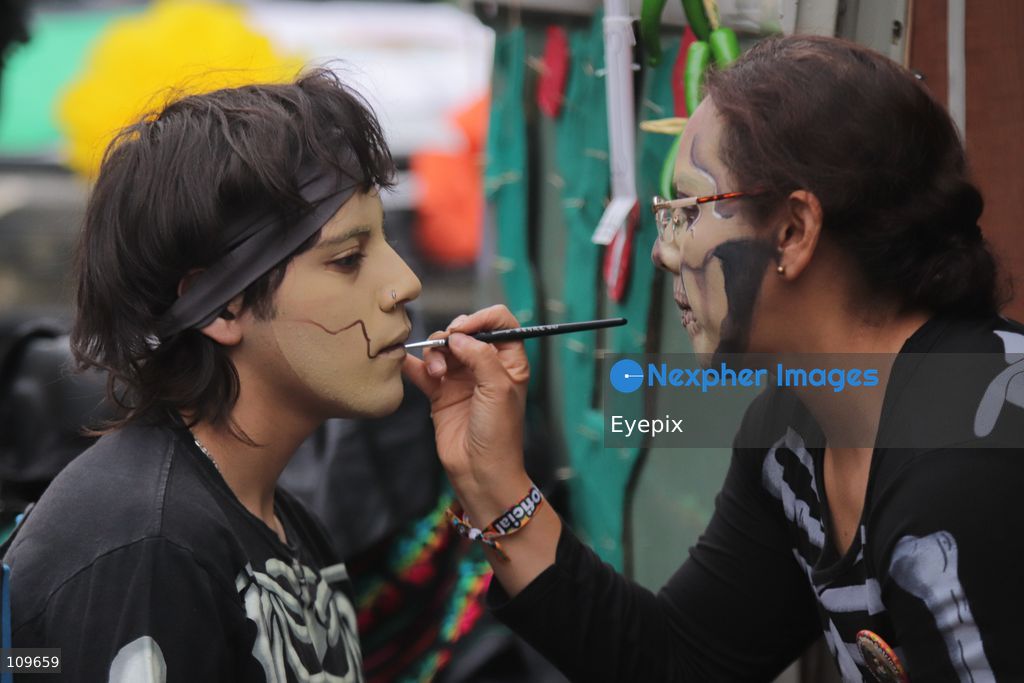 An artist applies skull makeup to a participant during the 13th annual Mega Procession of Catrinas along Paseo de la Reforma avenue. Thousands of persons gathered for the massive parade, a key cultural prelude to the upcoming Day of the Dead (Día de Muertos) celebrations, showcasing elaborate makeup, vibrant costumes, and honoring Mexican skull iconography. on October 25, 2026 in Mexico City, Mexico. (Photo by Carlos Santiago/ Eyepix Group/Eyepix via Nexpher Images)