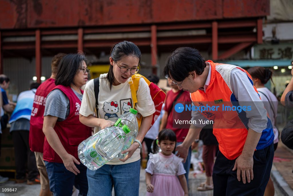 Residents receiving bottled water from workers after a water main burst in Shau Kei Wan on October 27, 2026 in Hong Kong. (Photo by Vernon Yuen/Nexpher Images)