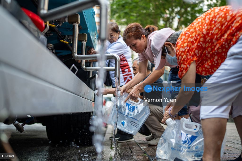 Residents filling up plastic water containers at a water truck after a water main burst in Shau Kei Wan on October 27, 2026 in Hong Kong. (Photo by Vernon Yuen/Nexpher Images)