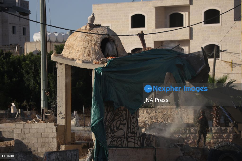 DURA, PALESTINE, OCTOBER 29, 2026: Israeli forces use a military bulldozer to demolish a memorial mural depicting Bajis Abu Atwan in the town of Dura, southwest of Hebron in the occupied West Bank. The demolition takes place during an Israeli military raid on the town. (Photo by Mosab shawer/JNA Press via Nexpher Images)
