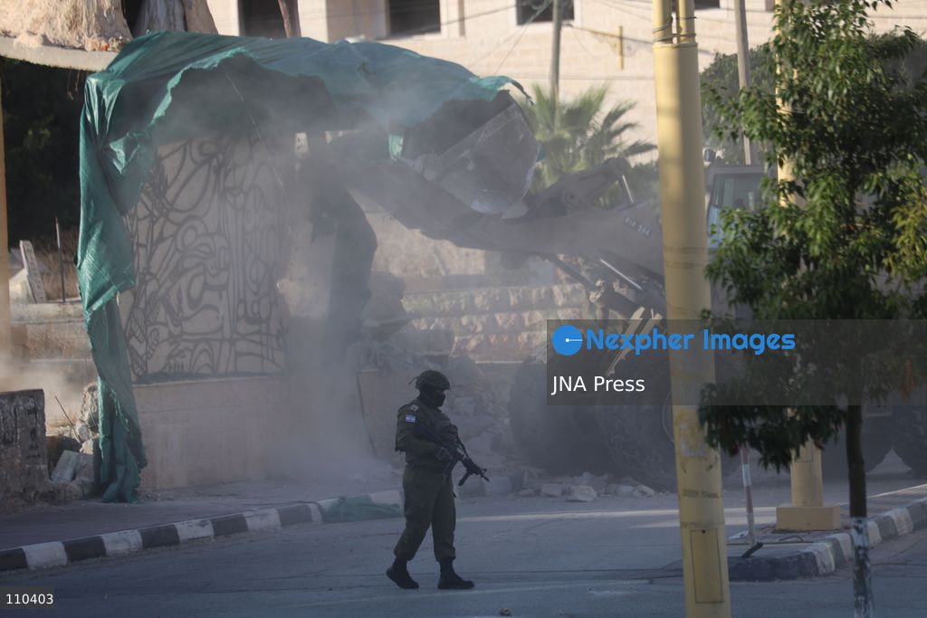 DURA, PALESTINE, OCTOBER 29, 2026: Israeli forces use a military bulldozer to demolish a memorial mural depicting Bajis Abu Atwan in the town of Dura, southwest of Hebron in the occupied West Bank. The demolition takes place during an Israeli military raid on the town. (Photo by Mosab shawer/JNA Press via Nexpher Images)