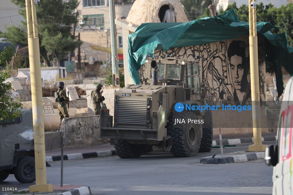 DURA, PALESTINE, OCTOBER 29, 2026: Israeli forces use a military bulldozer to demolish a memorial mural depicting Bajis Abu Atwan in the town of Dura, southwest of Hebron in the occupied West Bank. The demolition takes place during an Israeli military raid on the town. (Photo by Mosab shawer/JNA Press via Nexpher Images)
