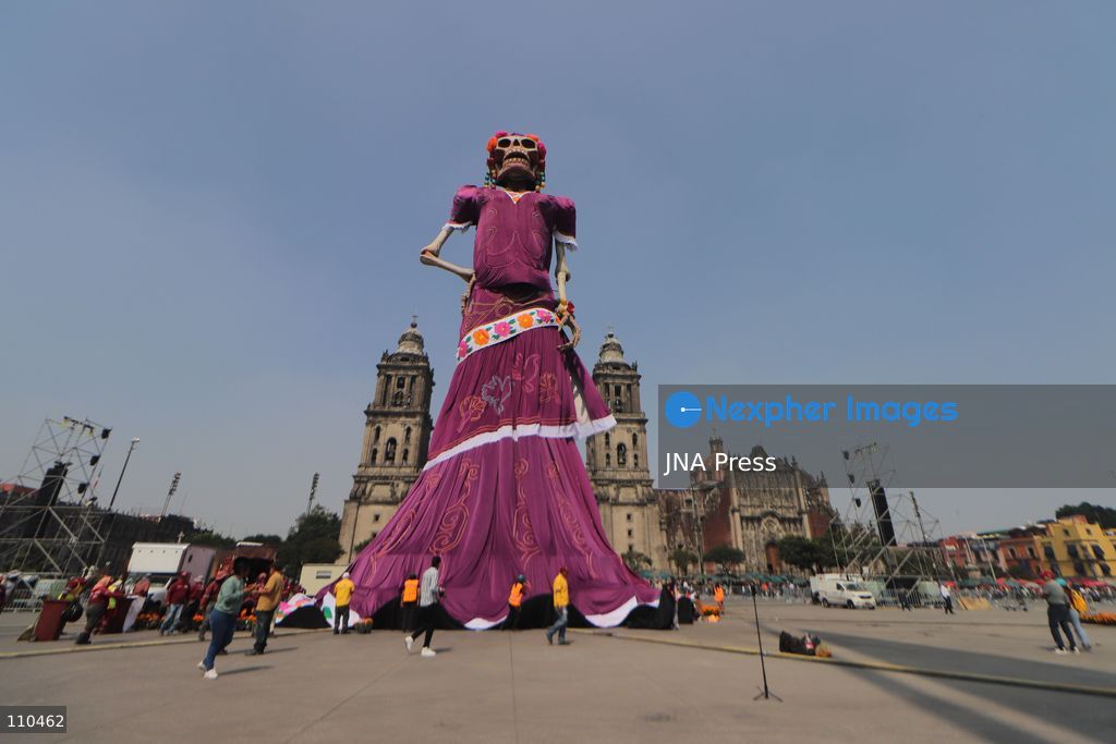 A monumental Catrina stands in Mexico City's Zócalo as the centerpiece of the 2026 Ofrenda Monumental. The roughly 32-meter figure, created by the Xibalbá art workshop, was unveiled as part of the Day of the Dead offering, which organizers said set a Guinness World Record for the tallest Catrina. The installation also features pieces from the exhibition "Ajolotes en el Corazón" and cempasúchil flowers. (Photo by Carlos Santiago/JNA Press via Nexpher Images)