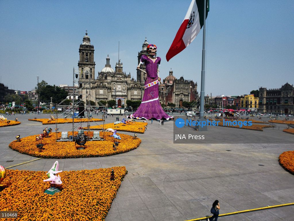 A monumental Catrina stands in Mexico City's Zócalo as the centerpiece of the 2026 Ofrenda Monumental. The roughly 32-meter figure, created by the Xibalbá art workshop, was unveiled as part of the Day of the Dead offering, which organizers said set a Guinness World Record for the tallest Catrina. The installation also features pieces from the exhibition "Ajolotes en el Corazón" and cempasúchil flowers. (Photo by Carlos Santiago/JNA Press via Nexpher Images)