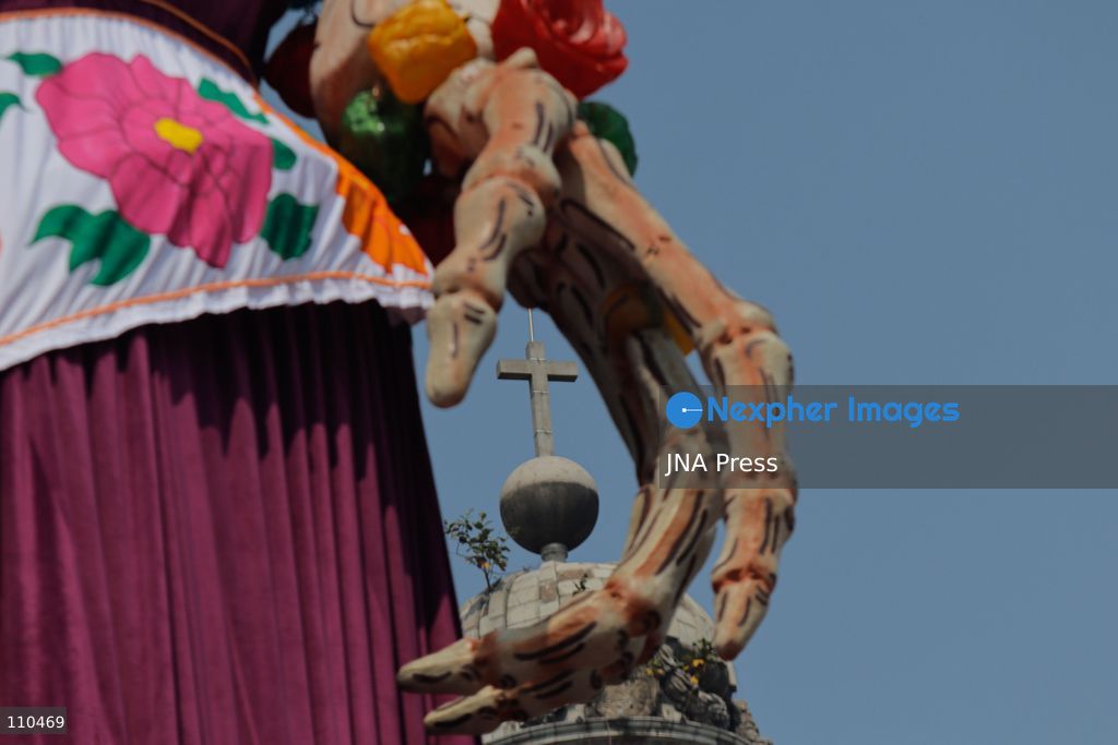A monumental Catrina stands in Mexico City's Zócalo as the centerpiece of the 2026 Ofrenda Monumental. The roughly 32-meter figure, created by the Xibalbá art workshop, was unveiled as part of the Day of the Dead offering, which organizers said set a Guinness World Record for the tallest Catrina. The installation also features pieces from the exhibition "Ajolotes en el Corazón" and cempasúchil flowers. (Photo by Carlos Santiago/JNA Press via Nexpher Images)