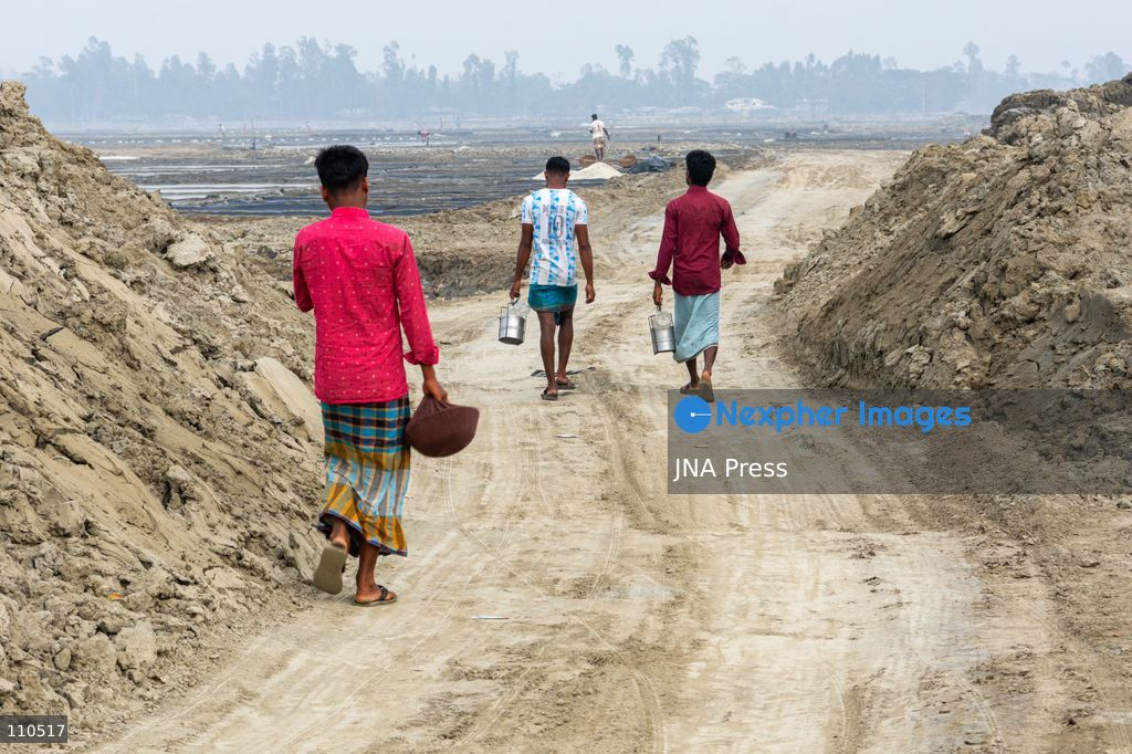 CHATTOGRAM, BANGLADESH - OCTOBER 30, 2026: Workers harvest salt from evaporation ponds lined with black polyethylene sheeting, scooping crystallized salt into mounds and carrying it in woven bamboo baskets. Seawater is held in the ponds and evaporated by sunlight over two to three days before harvesting. (Photo by Sohel Chowdhury/JNA Press via Nexpher Images)