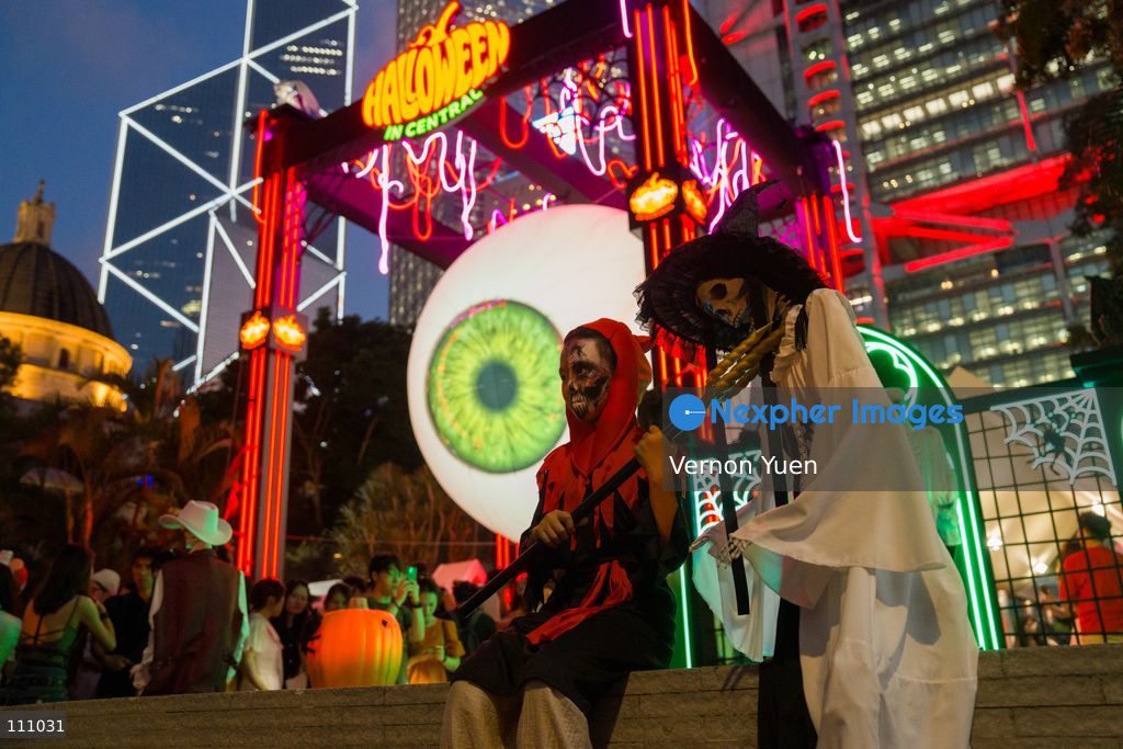 A person dress in a costume sitting next to a Halloween decoration at a Halloween market in Central District on October 31, 2026 in Hong Kong. (Photo by Vernon Yuen/Nexpher Images)