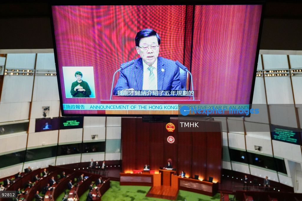 A high-angle wide view from the public gallery shows a television screen broadcasting the live feed as Hong Kong Chief Executive John Lee Ka-chiu delivers his 2026 Policy Address at the Legislative Council chamber on September 16, 2026 in Hong Kong. (Photo by Zulu Lo/TMHK via Nexpher Images)