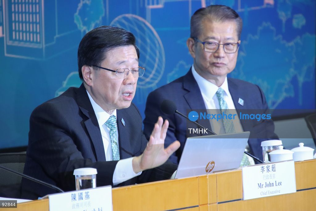 A close-up view shows Hong Kong Chief Executive John Lee Ka-chiu gesturing as he speaks during the press conference on the 2026 Policy Address and the "First Five-Year Plan of Hong Kong" on September 16, 2026 in Hong Kong. Financial Secretary Paul Chan Mo-po is seen out of focus in the background. (Photo by Gordon Choi/TMHK via Nexpher Images)