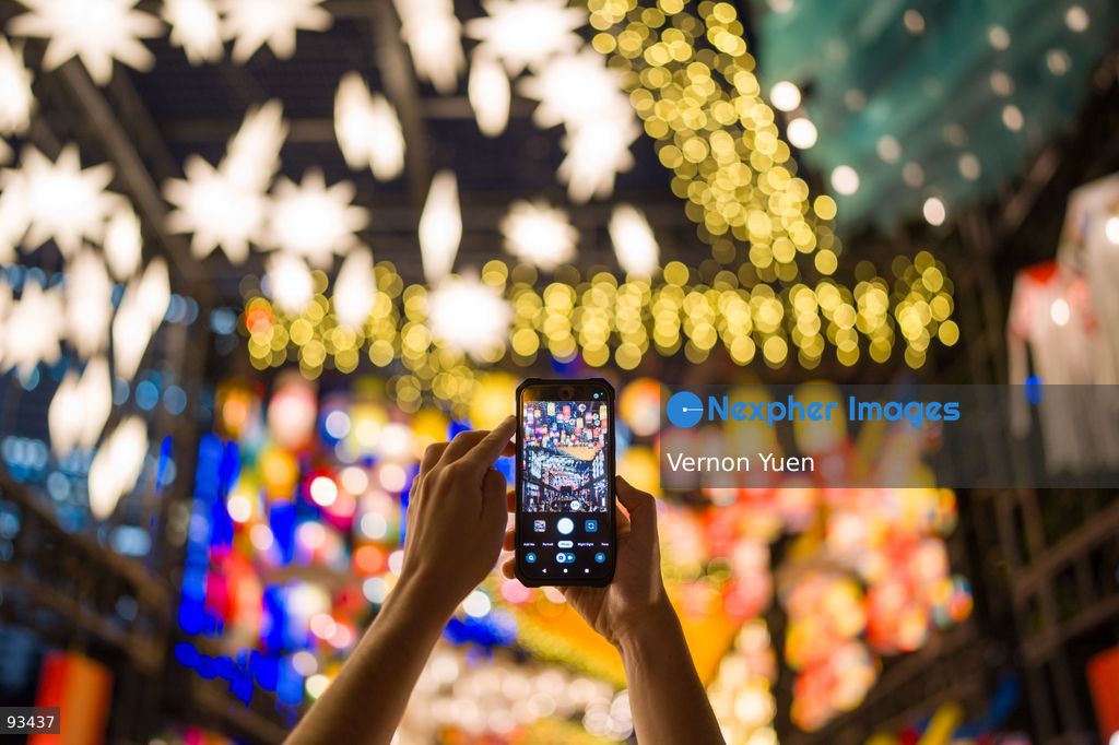 A Visitor using a phone to photograph the Mid Autumn Festival Lights at Victoria Park on September 17, 2026 in Hong Kong. (Photo by Vernon Yuen/Nexpher Images)