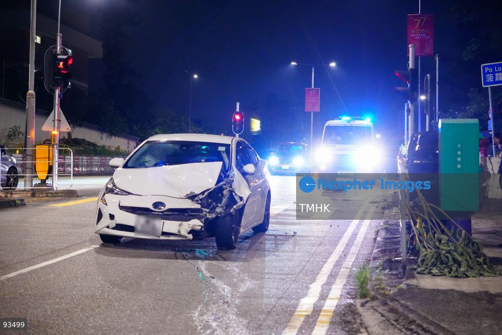 A police vehicle is parked behind the damaged white Toyota Prius, its license plate blurred in accordance with privacy practice, with flashing lights as officers investigate a two-car crash on Hiram's Highway near Po Lo Che Road on September 17, 2026 in Hong Kong. (Photo by Zulu Lo/TMHK via Nexpher Images)