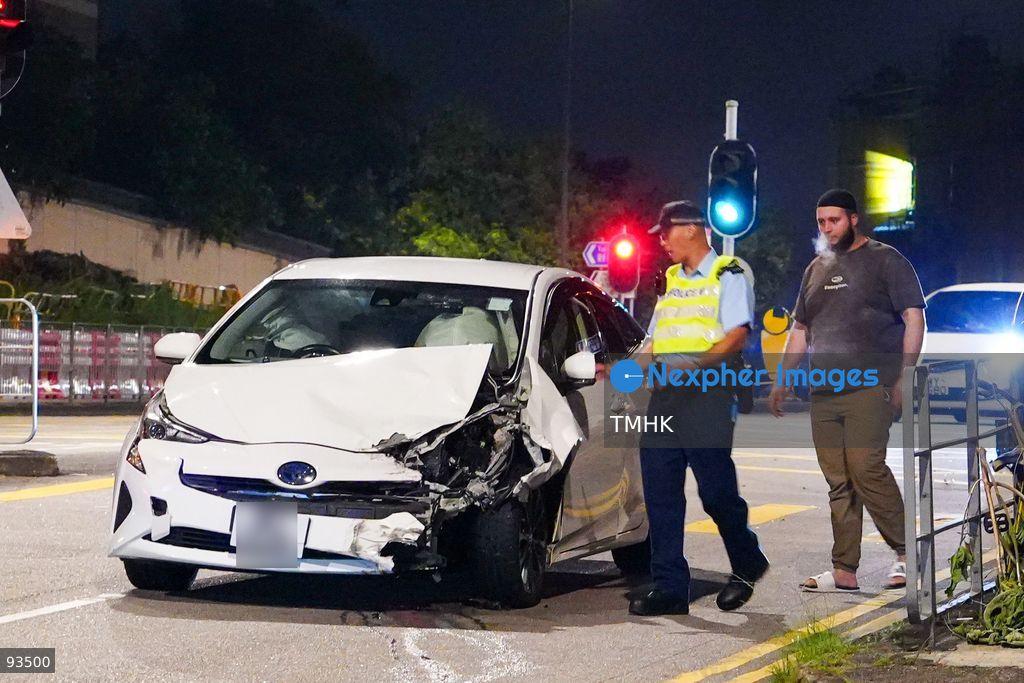 Police officers question the driver of the white Toyota Prius, its license plate blurred in accordance with privacy practice, beside the vehicle following a two-car collision on Hiram's Highway near the junction with Po Lo Che Road on September 17, 2026 in Hong Kong. (Photo by Zulu Lo/TMHK via Nexpher Images)